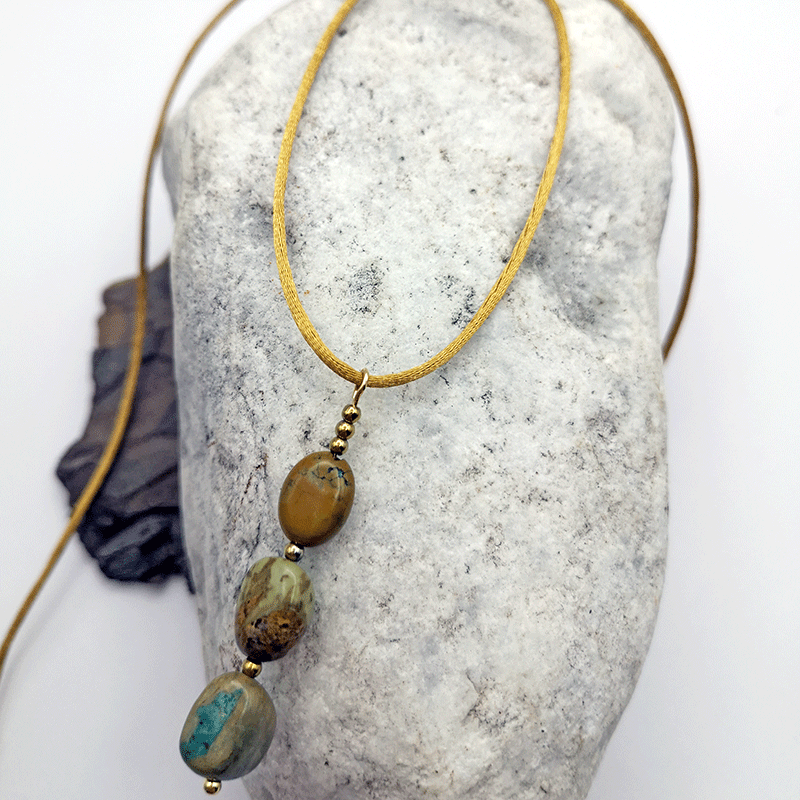 satinhalskette in gold mit anhänger aus afrikanischen tuerkis in den farben tuerkis grün blau senf und caramel