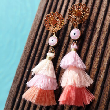 ohrringe mit edelstahl stecker in gold im boho stil mit einer rosa blaues auge perle und einer quaste in rosa orange und lachs